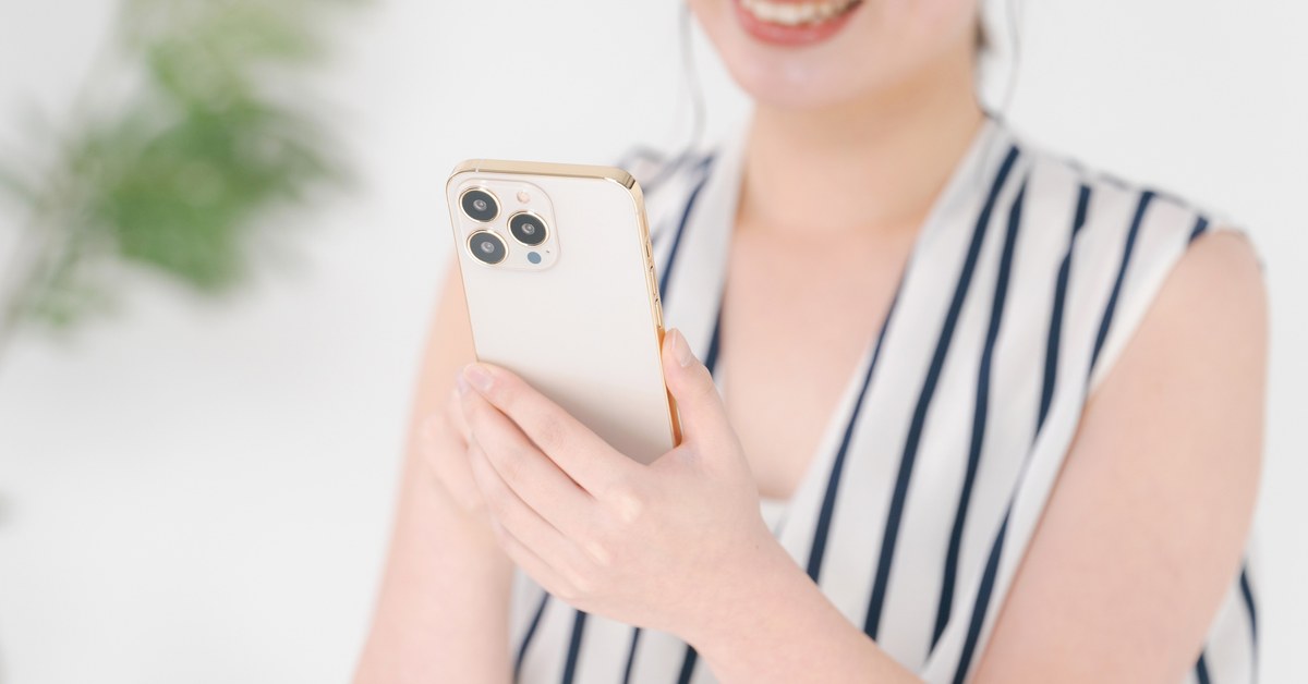 スマートフォンを手に持って画面を見る女性