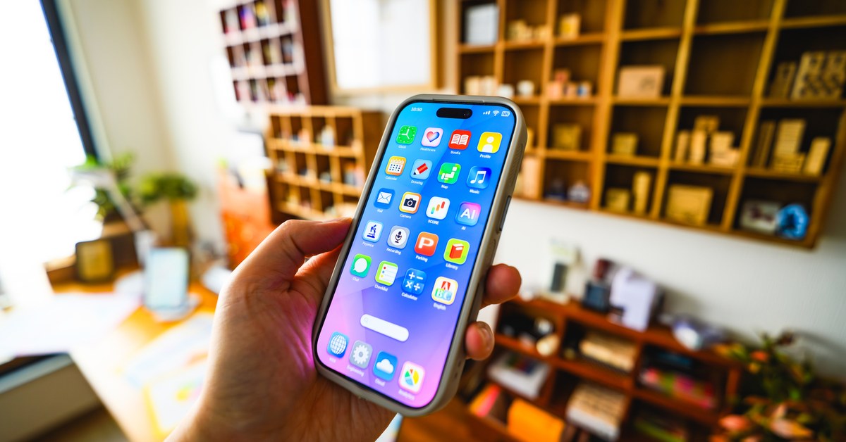アプリが並んだスマートフォンの画面を持つ手元