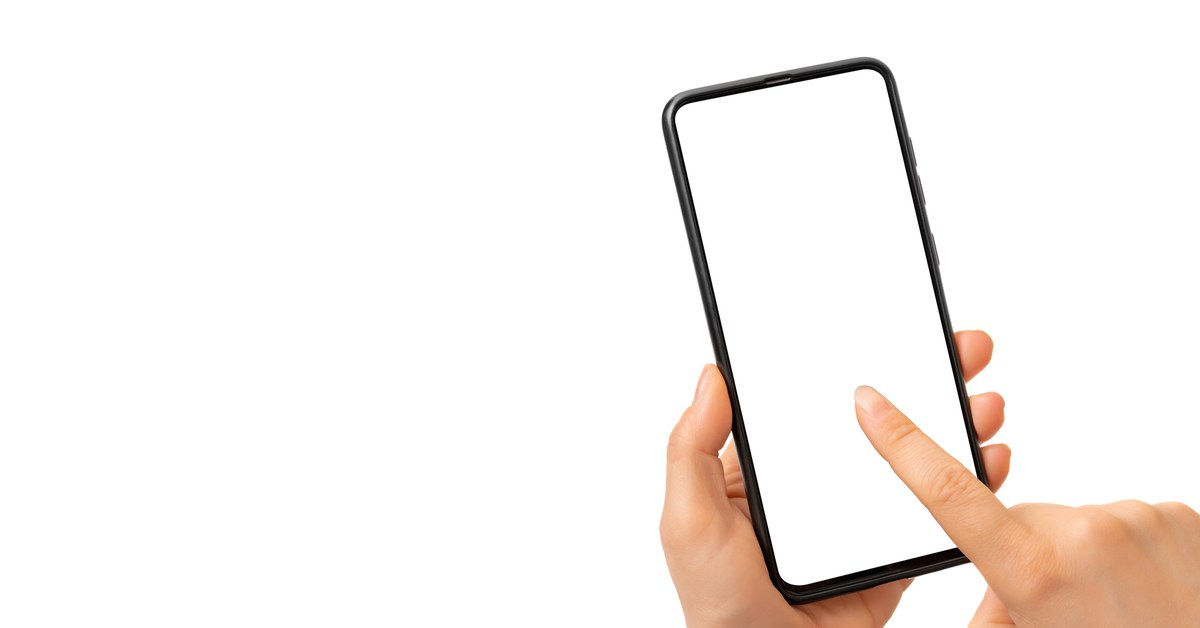 スマートフォンの画面を指でタップしようとする手元